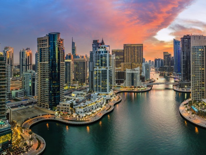 Dubai Marina ao entardecer, com os arranha-céus refletidos na água